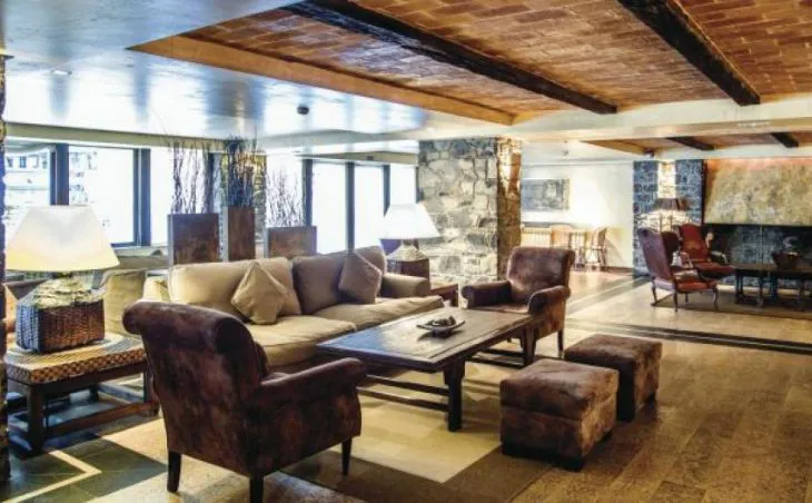Ski holidays in Arinsal. A photo of the stylish hotel lobby at Hotel Patagonia. Sofas, and coffee table and stone walls.