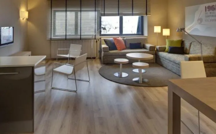 Ski holidays in Pas de la Casa Andorra. A photo of a living space at Hotel Sporting showing comfortable seating and a tv