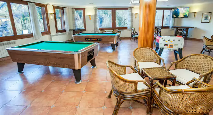 Ski holidays La Massana - The games room of Hotel Marco Polo La Massana, Andorra showing pool tables, tables, chairs and other games.