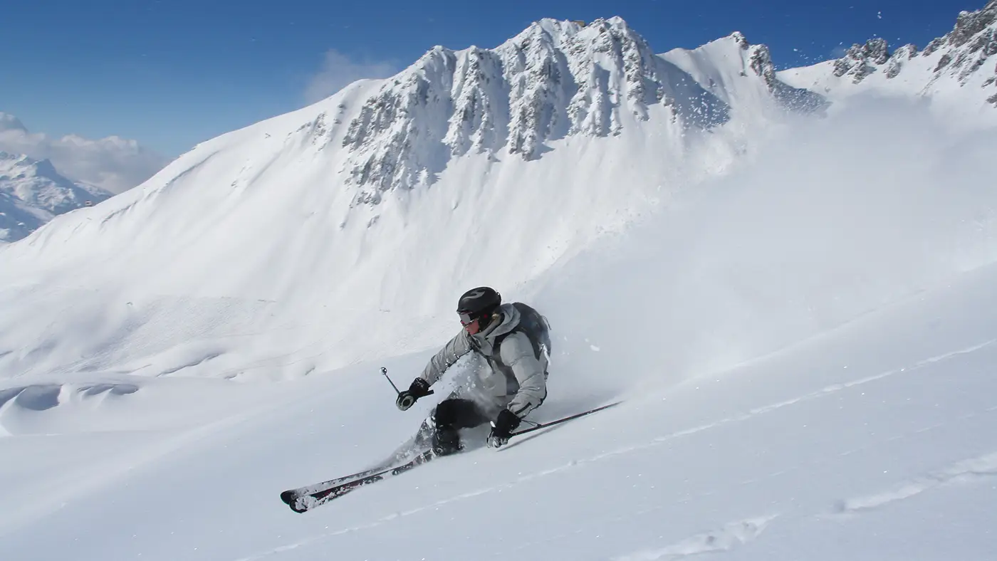 An advanced skier carving powder snow in St Anton, Austria