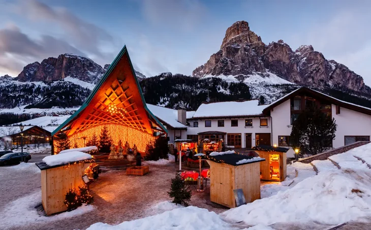 A stage or shelter with a modern design is illuminated, with a Christmas display at the ski resort of Corvara in Italy