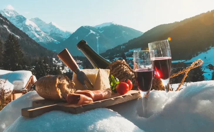 A selection of Italian Food and Wine on the Ski Slopes with mountains pictured in the background