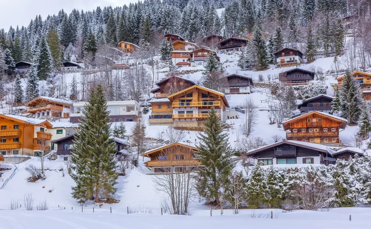 Quaint Austrian wooden ski chalets are shown on a mountain side in the resort of Sallbach